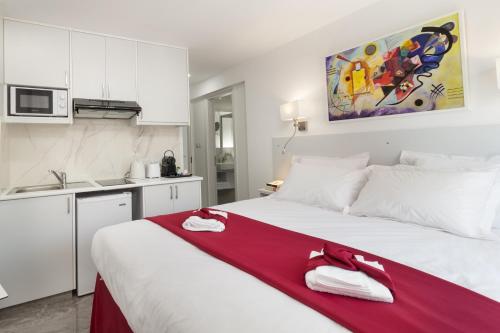 a bedroom with a large white bed with a red blanket at Art & Wine Boutique Hotel in Larnaka