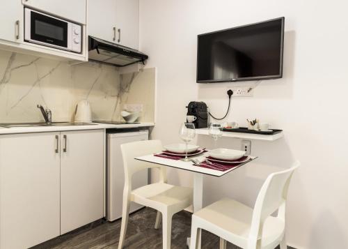 a kitchen with a table and chairs and a microwave at Art & Wine Boutique Hotel in Larnaka
