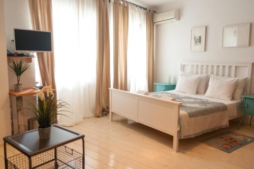 1 dormitorio con 1 cama, TV y mesa en Indigo Inn Rooms, en Split