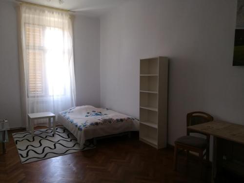 a small bedroom with a bed and a window at Ferdinand Apartments in Mediaş