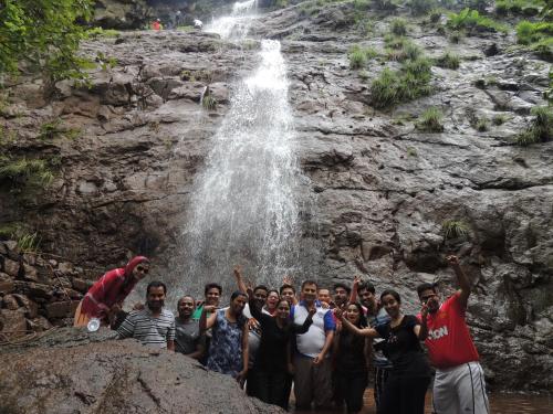 a group of people standing in front of a waterfall at Avanti Kalagram Hill Top Resort, Mulshi in Kolvan
