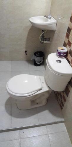 a bathroom with a toilet and a sink at Hotel Torres del Parque No3 in Barranquilla
