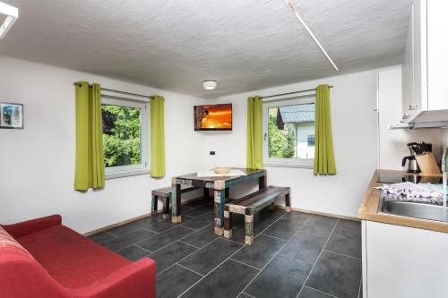 a living room with a red couch and a table at Appartement Leogang in Leogang