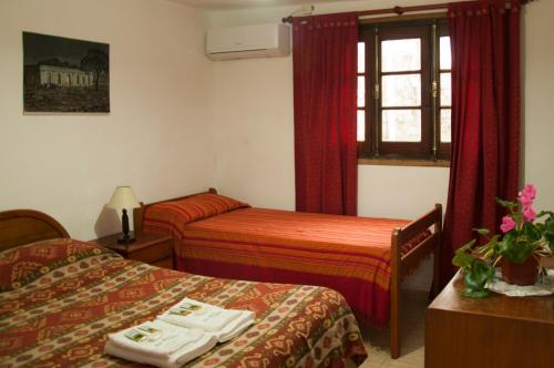 a hotel room with two beds and a window at Hostería La Pergola in Villa Serranita