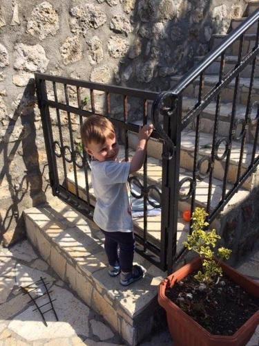 a young boy standing next to a fence at Apartments Antigona Old Town in Ulcinj