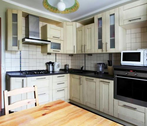 モスクワにあるApartment Nice on Presnenskiy Valの白いキャビネットと白い電子レンジ付きのキッチンが備わります。