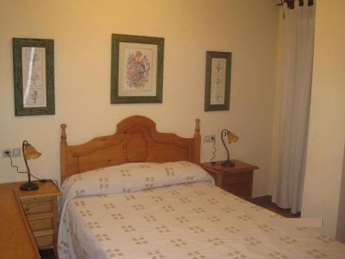 1 dormitorio con 1 cama y 2 lámparas en la pared en Apartamento Rural Lobo, en Ucero
