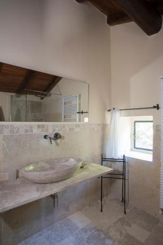 a bathroom with a large stone sink on a counter at Tenuta Folesano Wine Estate 13th century in Marzabotto