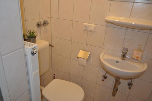 La salle de bains est pourvue de toilettes et d'un lavabo. dans l'établissement Weinstube Heigl Restaurante Pizzeria Puccini, à Landshut