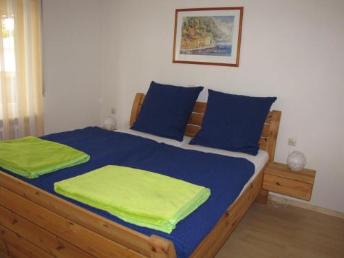 a bedroom with a bed with blue and green sheets at Ferienwohnung Dettenhausen in Dettenhausen