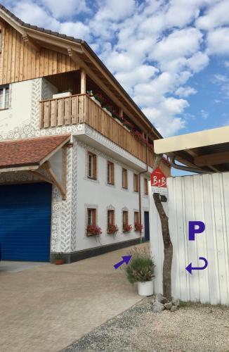 a large white building with a blue garage at Conny's B&B in Niederweningen