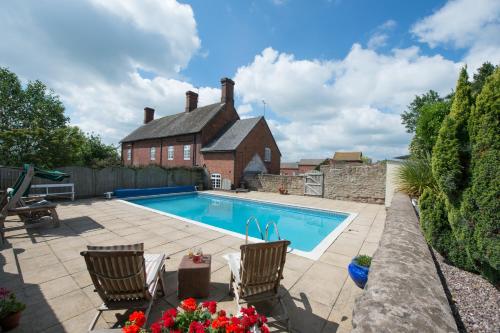 a swimming pool in front of a house at Cart Shed Cottage in Newport