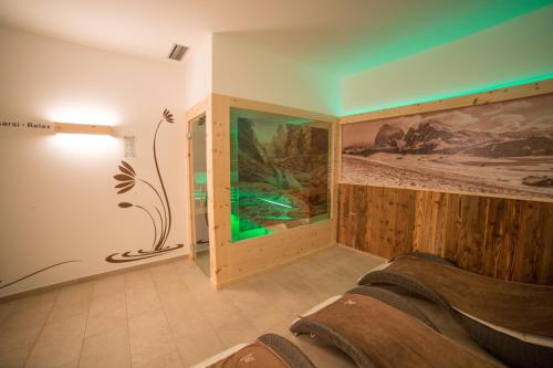 a bedroom with a wall with a painting on it at Hotel Garni Savoy - new opening in Castelrotto