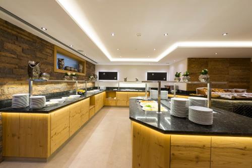 a restaurant with a counter with plates on it at Hotel Post in Kaltenbach