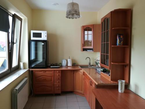 a kitchen with wooden cabinets and a counter top at Pokoje Goscinne Lawenda II in Sandomierz