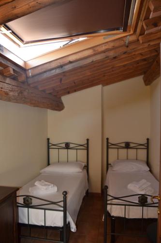 two beds in a room with a skylight at Antico Borgo Casalappi in Campiglia Marittima