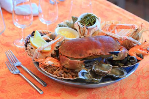 a plate of lobster and other foods on a table at Hôtel L'Escale - Piscine & SPA in Escalles