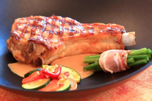 a piece of meat and vegetables on a plate at Hôtel L'Escale - Piscine & SPA in Escalles