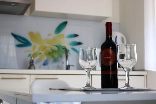 a bottle of wine and two wine glasses on a counter at Sweet Apartments in Split