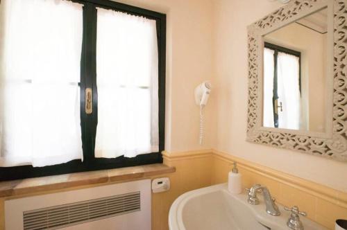 a bathroom with a tub and a sink and a mirror at Dimora Borgogni: Country House in Perugia