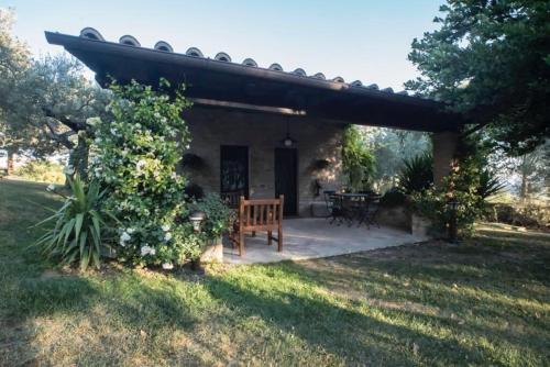 d'une terrasse avec un banc et une table dans la cour. dans l'établissement Dimora Borgogni: Country House, à Pérouse