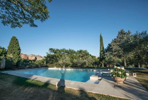 a large swimming pool in a yard with trees at Dimora Borgogni: Country House in Perugia