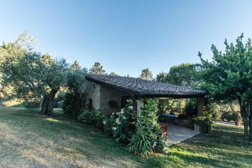 uma casa de pedra com um gazebo num quintal em Dimora Borgogni: Country House em Perugia