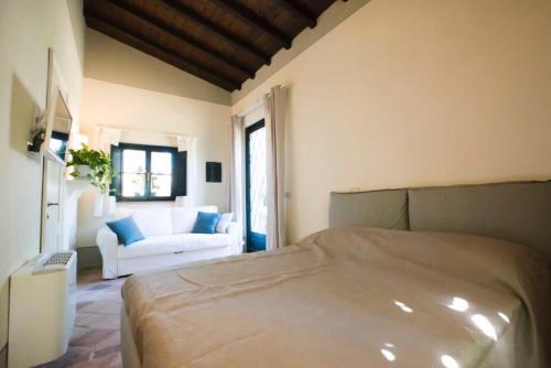 a bedroom with a bed and a couch in a room at Dimora Borgogni: Country House in Perugia