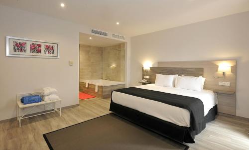 a bedroom with a large bed and a bathroom at Hotel Salobreña Suites in Salobreña