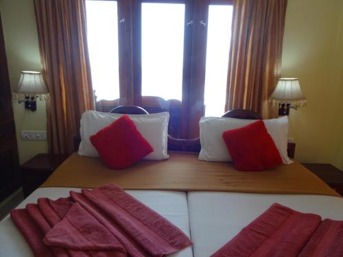 a bedroom with a bed with red and white pillows at Hotel Sea View Palace - the beach hotel in Kovalam