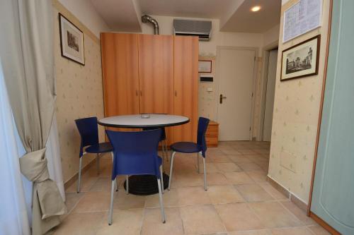 a dining room with a table and blue chairs at Hotel San Francisco Spiaggia in Rimini
