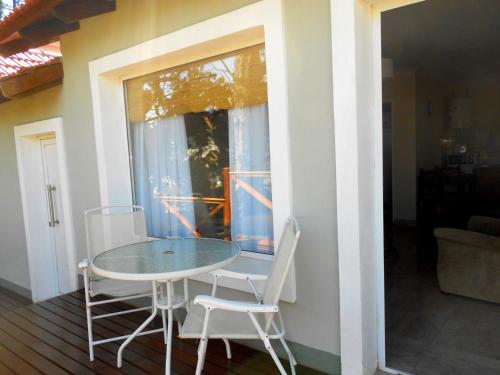 a table and two chairs sitting on a porch at Cabañas Valle Del Sol in Tandil