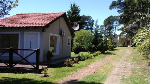 a small house with a gate and a dirt road at Cabañas Valle Del Sol in Tandil