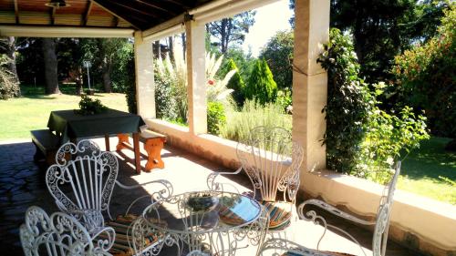 a patio with a table and chairs on a porch at Cabañas Valle Del Sol in Tandil