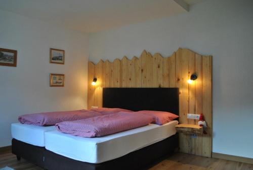 a bedroom with a large bed with a wooden wall at Chasa Chalur in Fliess