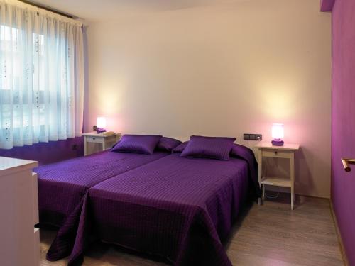 シエロにあるCasa Maminaのベッドルーム1室(紫色のベッド1台、テーブル2台、ランプ2つ付)