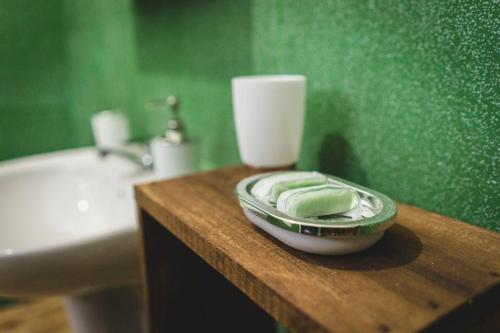 a green bathroom with a wooden counter with a sink and a toilet at Surfpoint Sri Lanka Kite Village in Kalpitiya