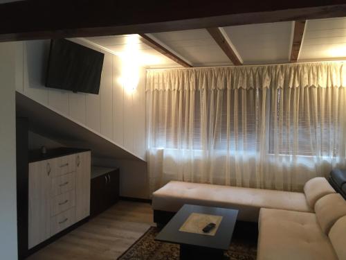 a living room with a couch and a table at Guest House Angelkovi in Sapareva Banya