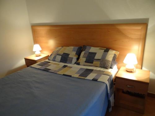 ein Schlafzimmer mit einem Bett und zwei Nachttischen mit Lampen in der Unterkunft Vue sur mer et montagnes in Moriani Plage