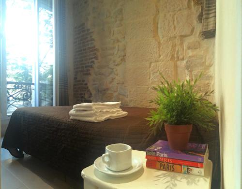 a bedroom with a bed and a table with books at Studio lumineux Paris centre - Chatelet in Paris