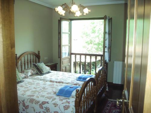 a bedroom with a bed and a large window at Casa Rural Josefina in Aliezo