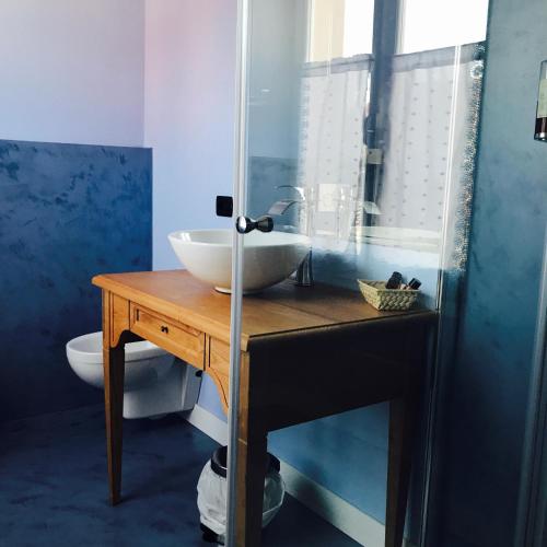 a bathroom with a bowl sink on a wooden table at Charming Rooms Opuntia in Carloforte