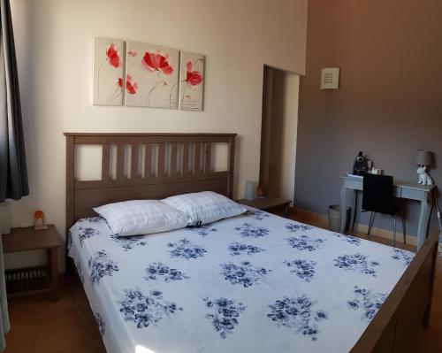 a bedroom with a bed with a blue and white comforter at B&B Les Grillons in Draguignan