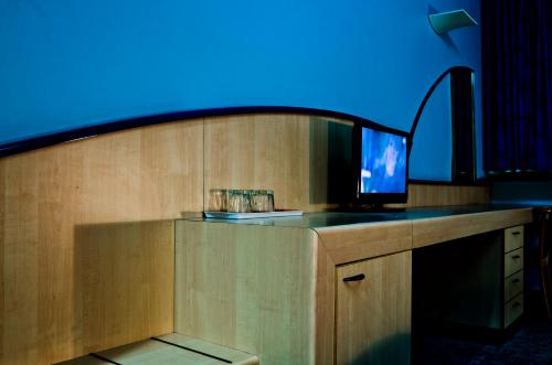 a room with a tv on a counter with a blue light at Kék Hold Hotel in Marcali