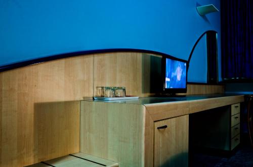 Zimmer mit einem TV auf einer Theke mit blauem Licht in der Unterkunft Kék Hold Hotel in Marcali