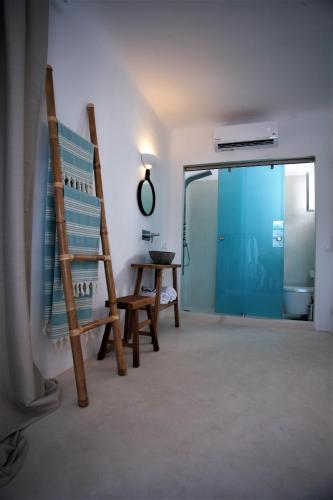 a room with a ladder and a chair and a table at Mykonos Moussa in Agios Ioannis Mykonos