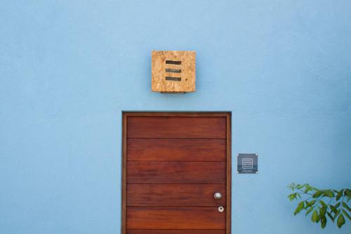 a blue wall with a sign above a wooden door at EsposendeGuesthouse in Esposende