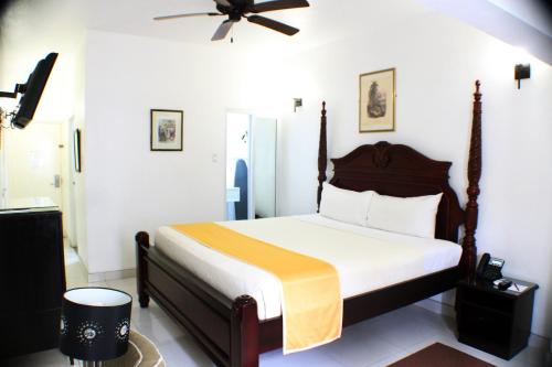 a bedroom with a bed and a ceiling fan at Altamont Court Hotel in Kingston