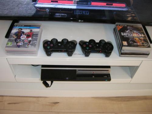a shelf with two video game controllers and two games at Appartement Fortuna in Saalfelden am Steinernen Meer