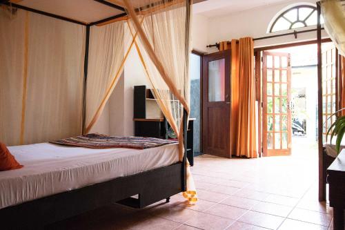 a bedroom with a bed with a canopy at Villa Taprobane in Negombo